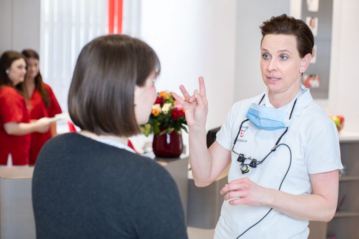 Dr. Verena Mönnich erklärt einer Patientin die Behandlung in Gebärdensprache
