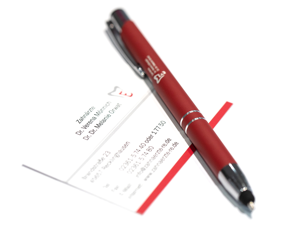 roter Stift und Visitenkarte der Praxis